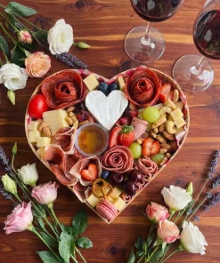 Tabla de quesos y carnes frías en forma de corazón con frutas y semillas para 2 personas en México